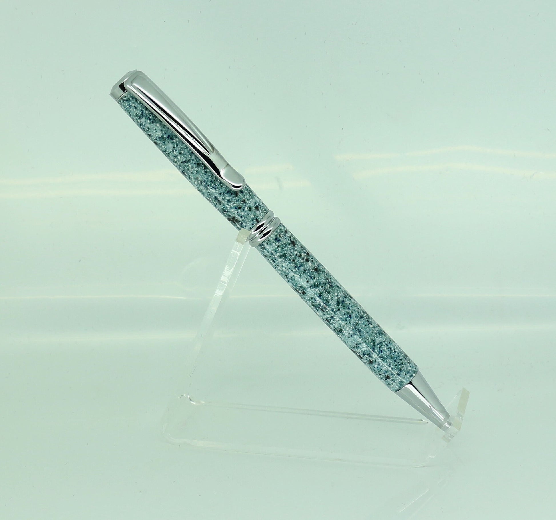 A pen standing upright and showing off the green Corian and mottled colours and effects to the full, complete with Chrome plated fitting to show the effect off.