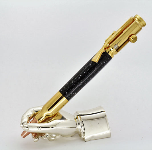 A right hand shaped metal base holding a handturned black Corian Bolt action pen as you would hold it to write with.