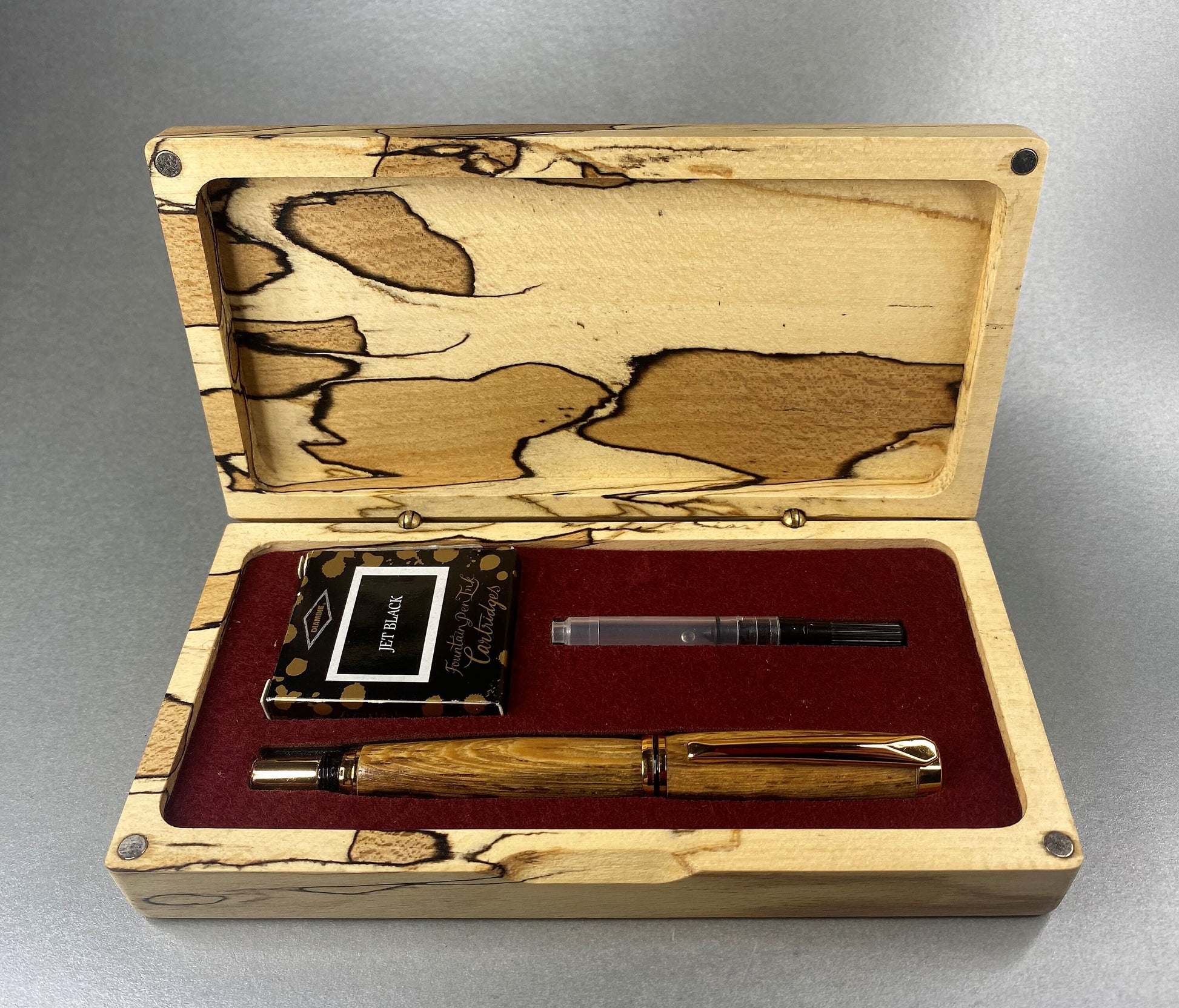 Spalted Beech wood hand crafted presentation box with its lid open showing one hand turned hand crafted pen made from Panga Panga Wood, It has Gold Plated fittings and black accents on the nib.