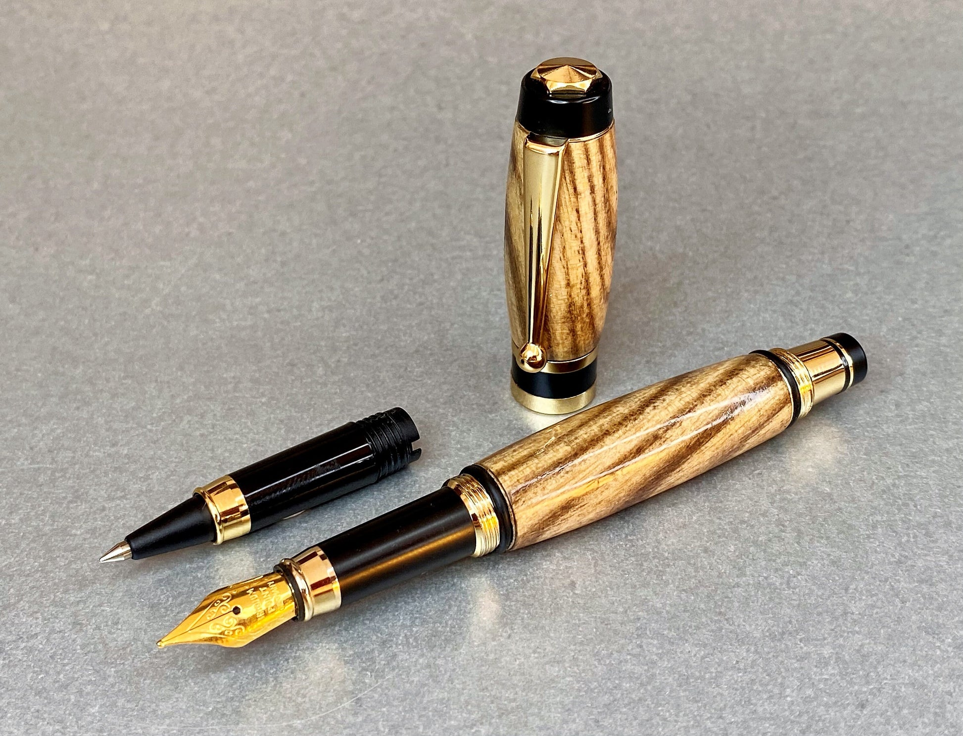 One hand turned hand crafted pen made from Black Ash Wood, It has Gold Plated fittings and black accents on the nib, there is a second nib that is a rollerball type so you can switch between the two.