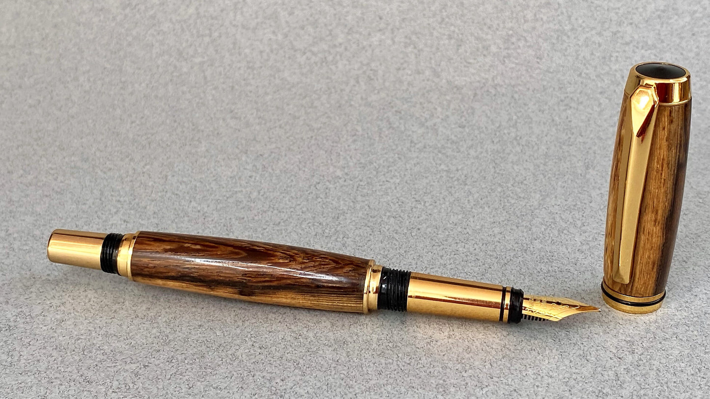 Panga Panga wood pen lying down showing its grain effect and gold plated nib
