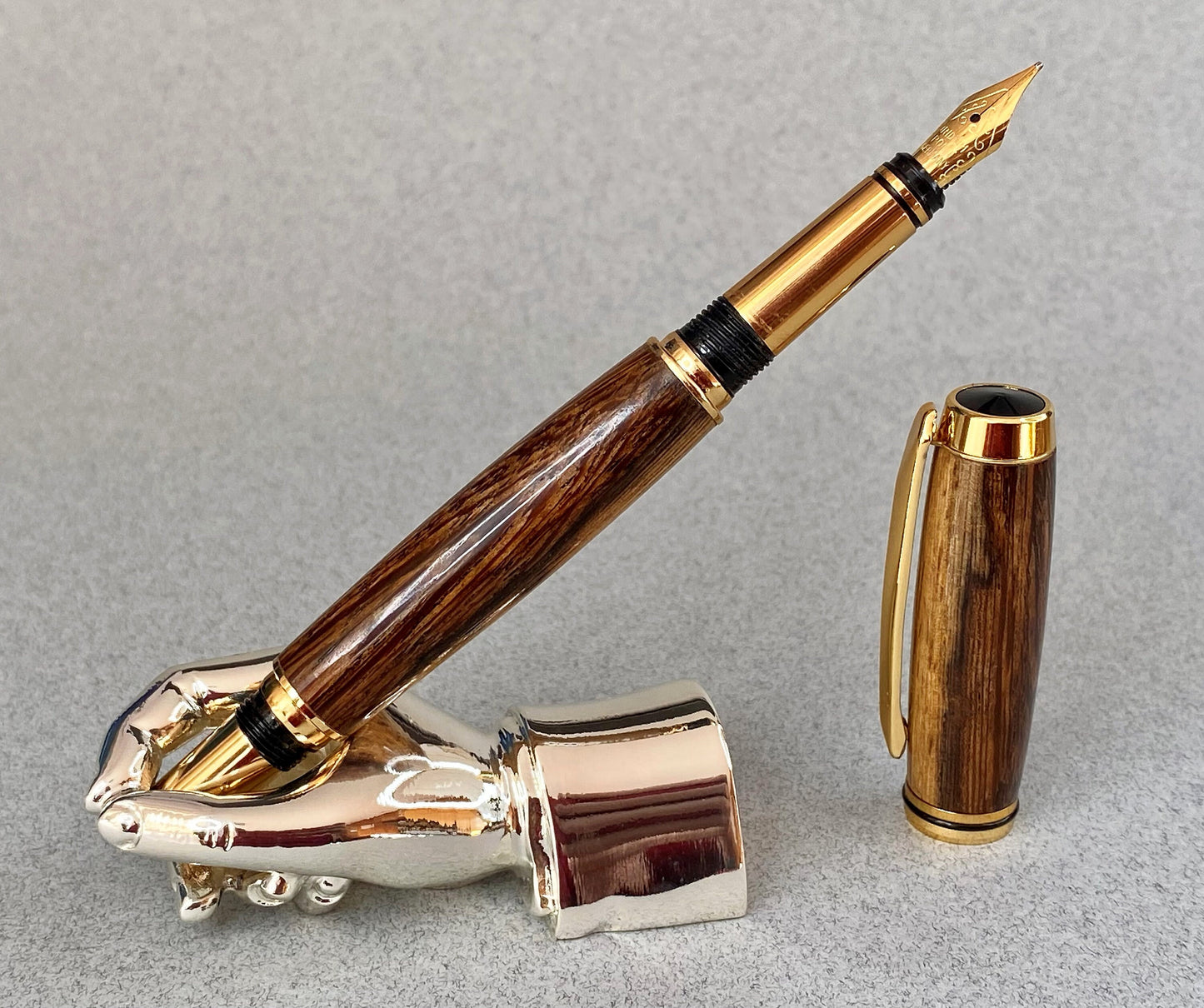 Panga Panga wood pen standing upright showing its grain effect and gold plated nib